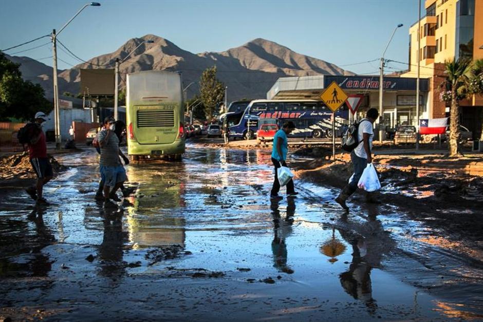 Un grupo de personas cruza una calle anegada en el centro de Copiapó en Chila. &nbsp;(Foto: EFE)