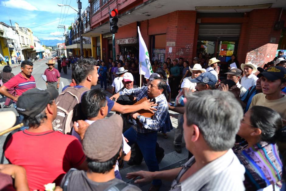 Un grupo de manifestantes cuestiona y empuja a un transeúnte que intento ingresar al Congreso. (Foto: Soy502/Wilder López)