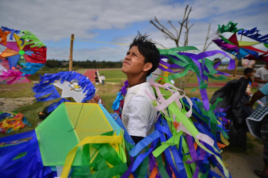 Un vendedor de barriletes se entretiene cuando observa como el viento hace de las suyas con las cometas que vuelan a lo lejos. (Foto: Wilder López/Soy502)