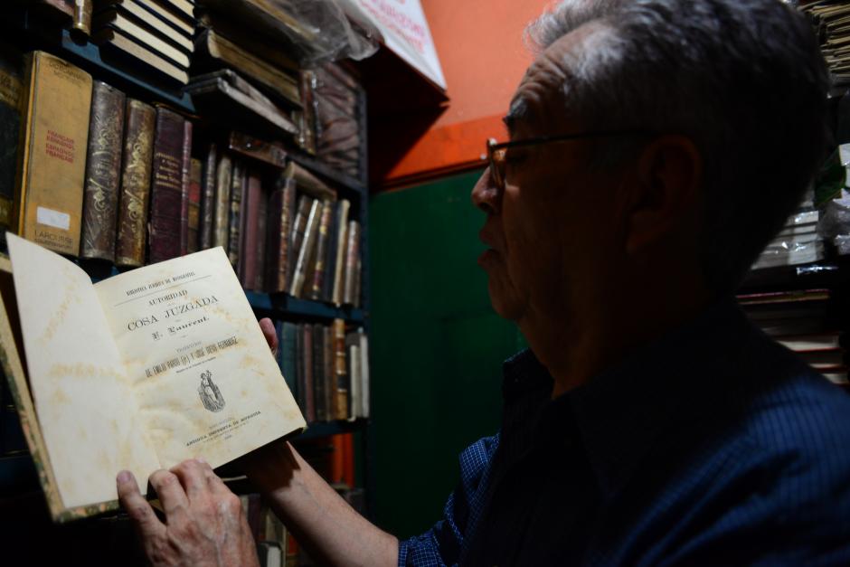 Julio Gálvez, propiertario de la librería "El Búho", muestra una copia de un libro de 1888; una verdadera reliquia entre su colección. (Foto: Jesús Alfonso/Soy502)