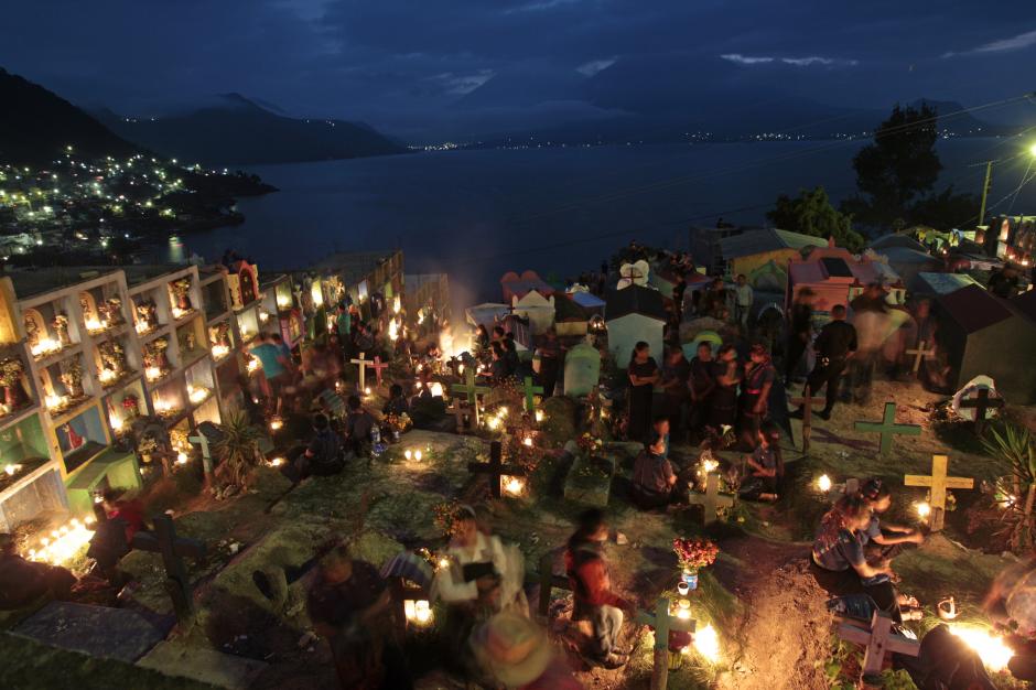 Cae la noche en San Antonio Palopó, y se iluminan las tumbas de los difuntos en el cementerio. Al fondo, el Lago de Atitlán. (Foto: Esteban Biba/ EFE)