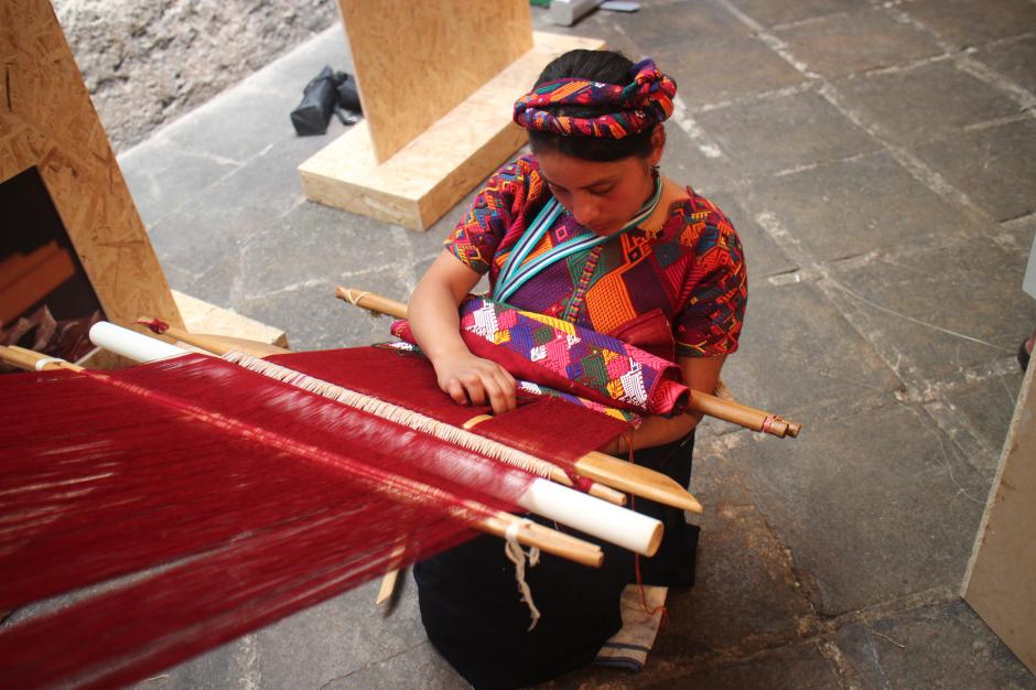 Una joven tejía en un telar durante la exhibición. (Foto: Alejandro Balán/Soy502)