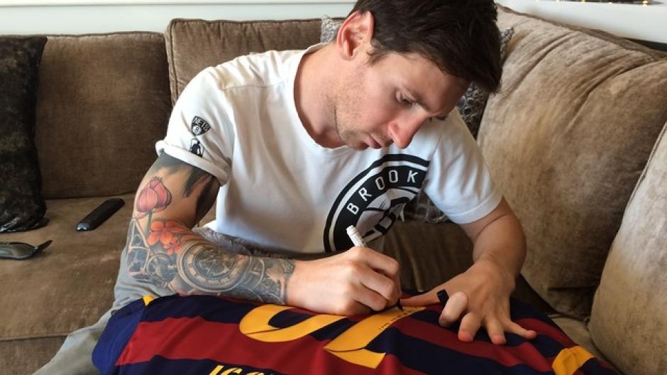 Lionel Messi escribe un mensaje especial en la camiseta que le envió como regalo a su amigo Ronaldinho para esta navidad. (Foto: FC Barcelona)