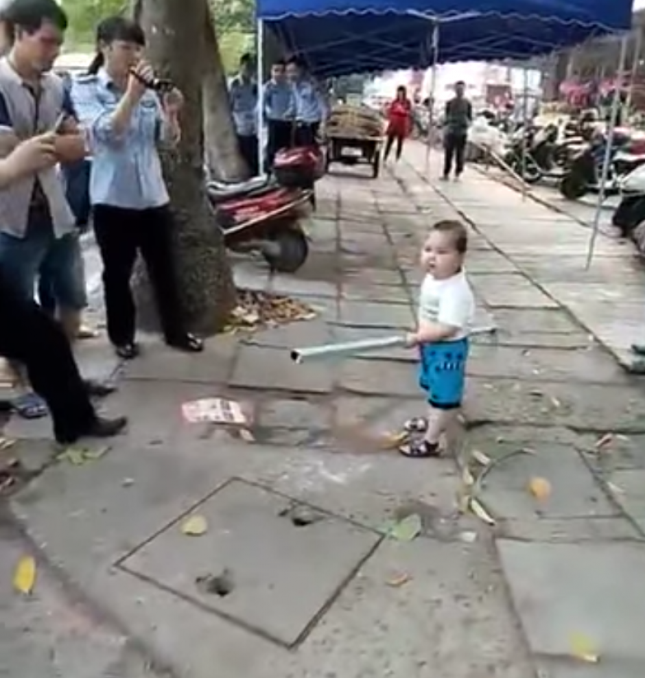 El niño se enfurece con los agentes policiales que pretendían desalojar a su abuela, una vendedora ambulante, de las calles de una ciudad en China. (Captura YouTube)