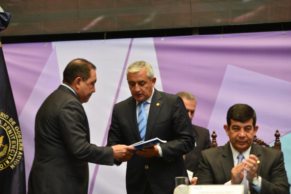 Mauricio López Bonilla (I), ministro de Gobernación, entrega el documento que contiene la Política Penitenciaria al presidente Otto Pérez Molina. (Foto: Jesús Alfonso/Soy502)