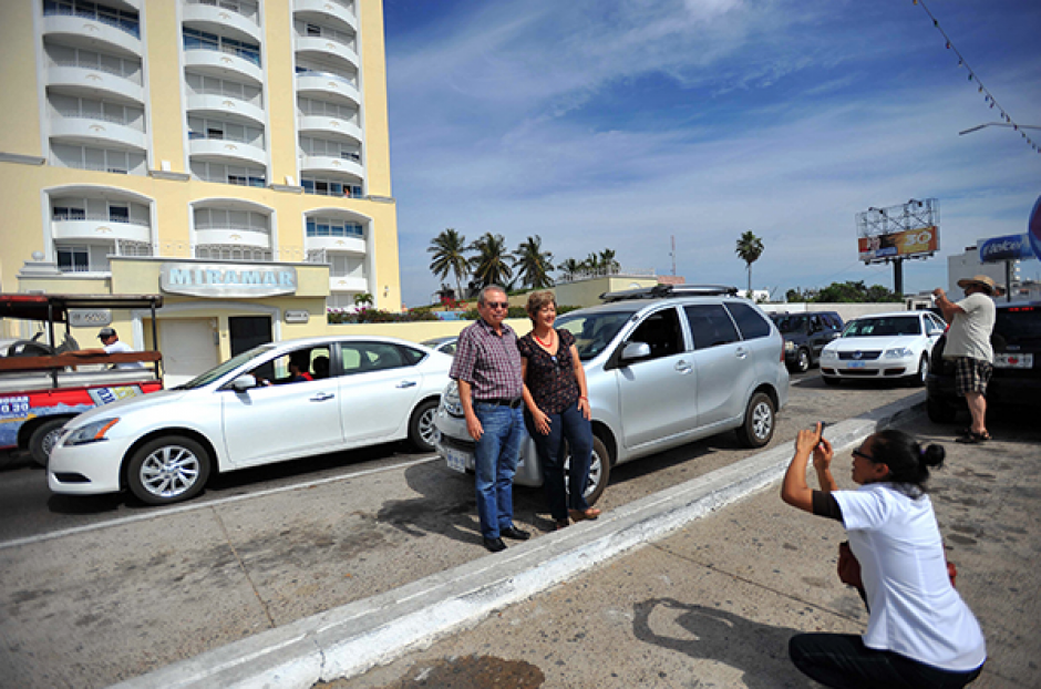 Turistas se toman fotos de recuerdo frente a la torre donde capturaron a Joaquín "el Chapo" Guzmán. (Foto: Milenio)