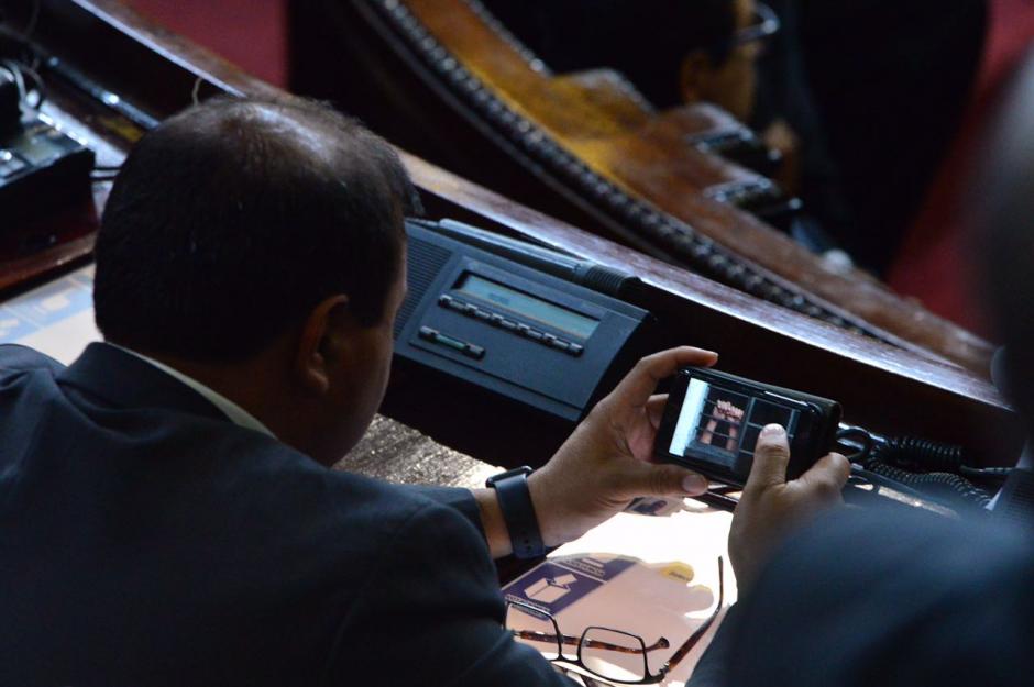 El diputado representante de Huehuetenango, Mike Mérida, mira videos en su curul. (Foto: Jesús Alfonso/Soy502)