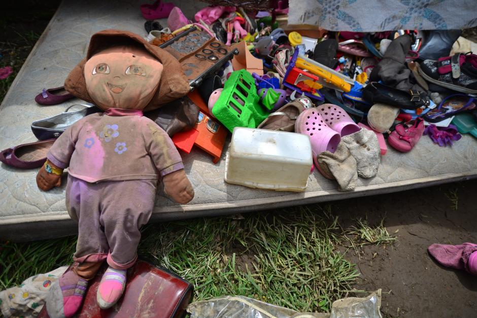 Una muñeca de "Dora, la exploradora" cubierta de lodo, es puesta sobre un colchón junto a otros juguetes para recibir el sol y secarse. (Foto: Wilder López/Soy502)