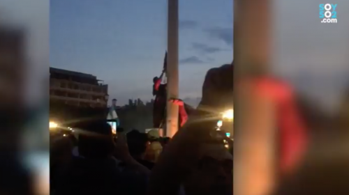 Manifestantes evitan izada de bandera y colocan una manchada de rojo