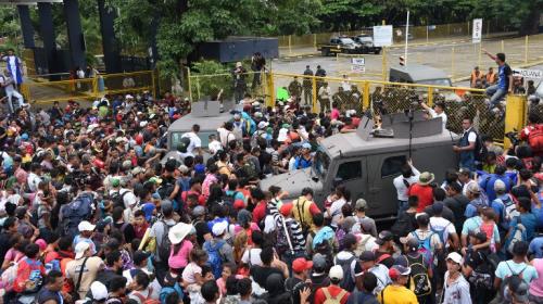 Migrantes hondureños derriban portones para llegar a México