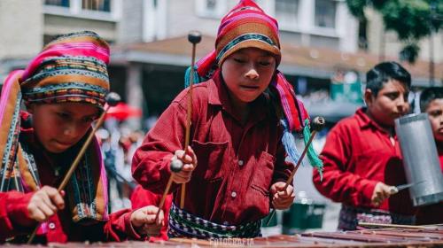Niños de banda escolar sorprenden tocando marimba en pleno desfile