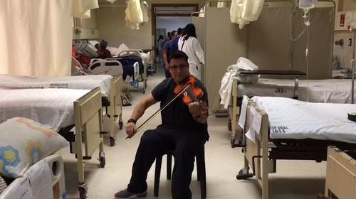 Médico del IGSS usa su violín para tocar villancicos a pacientes